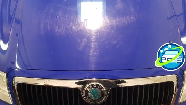 Vorher: Blaue Skoda-Motorhaube mit Spiegelung nach der Politur